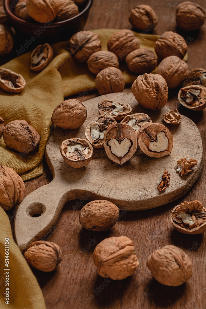 Open half walnuts and whole walnuts on a wooden table. Healthy food with natural protein. Nutrition for the brain. Open half walnuts and whole walnuts on a wooden table. Healthy food with natural protein. Nutrition for the brain.