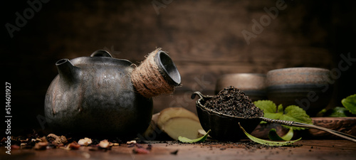 Loose tea with old teapot near cups photo