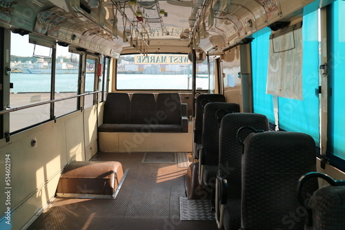 Neat and clean seats and pull tab handles inside a Japanese tour bus, bus scene