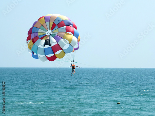  Parachuting at the sea. A parachutist flies over the sea. Summer sport and vacation near the sea concept .