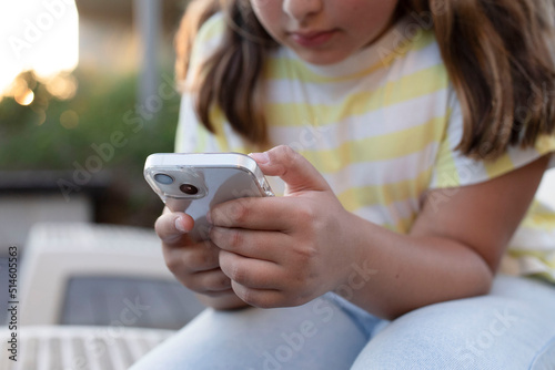 Modern smartphone in the hands of young girl. Typing  hands, mobile phone. Concept of influencer, follower, social media, online shopping, app, digital marketing, chat. Life style. Soft focus. Outside