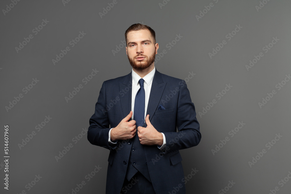 Smart brunette man wearing formal clothes looking at camera on grey background Smart brunette man wearing formal clothes looking at camera on grey background