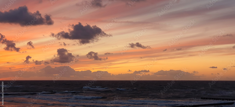 Fototapeta premium the black baltic sea and the red-orange sky above it
