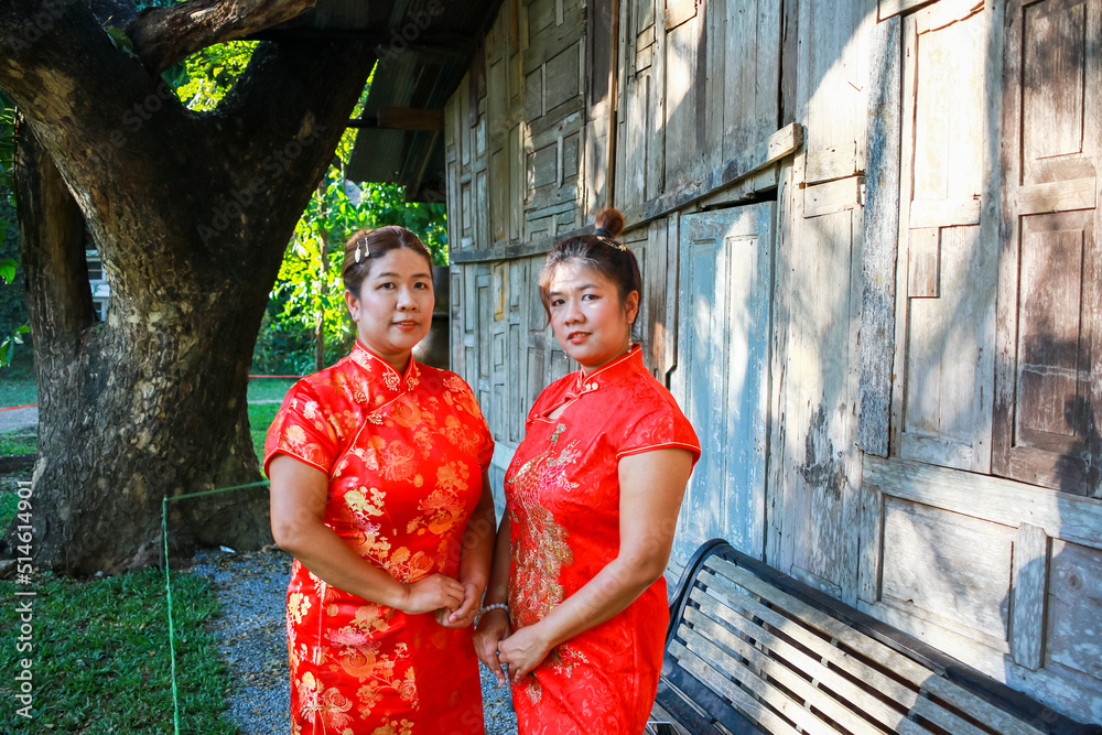 Obraz premium Two Asian Woman in Red Chinese Dress. Twins Girl in Chinese New Year.