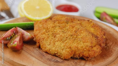 Chicken schnitzel on wooden cutting board. Fried chicken chops.
