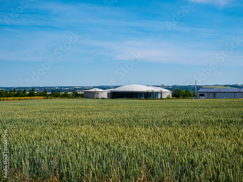 Biogas plant behind a wheat field