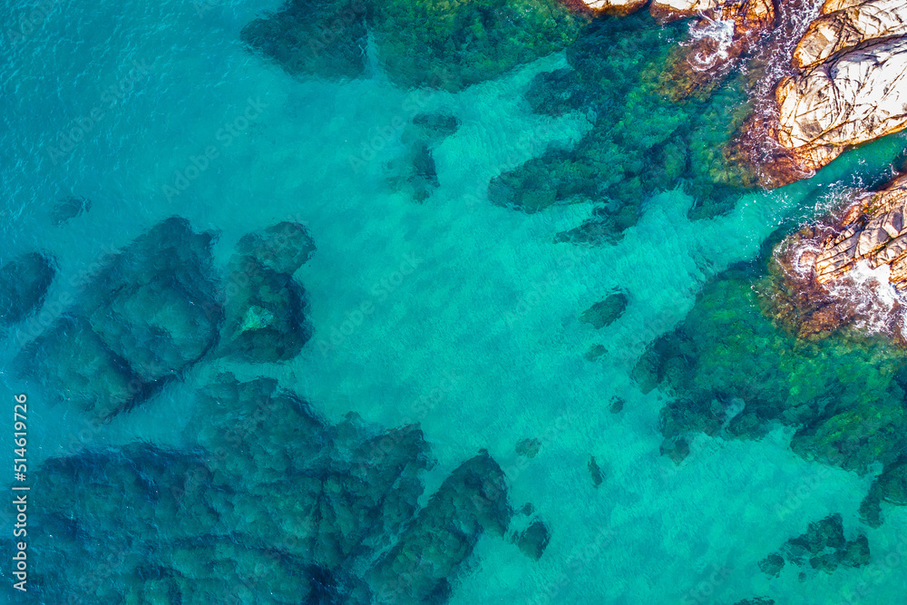 Fototapeta premium Aerial view over rocks landscape and blue turquoise sea at Costa Brava, Catalonia, Spain. Artistic summer background of the mediterranean coast. Summer conceptual background. Beach tourism vacations.