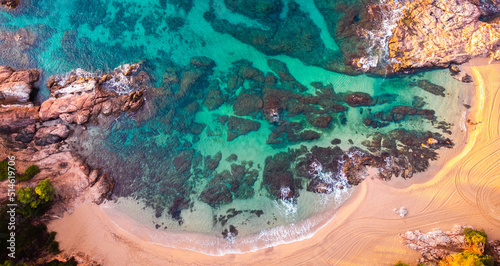 Fototapeta Naklejka Na Ścianę i Meble -  Aerial view of Sa Conca beach, Costa Brava, Catalunya, Mediterranean sea coast, Spain. Beach background with transparent turquoise blue water. Summer tourism. Beach vacations.
