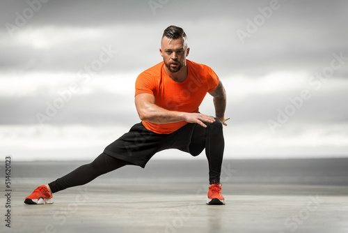 Fototapeta Naklejka Na Ścianę i Meble -  Athletic man doing fitness exercises on the ocean beach