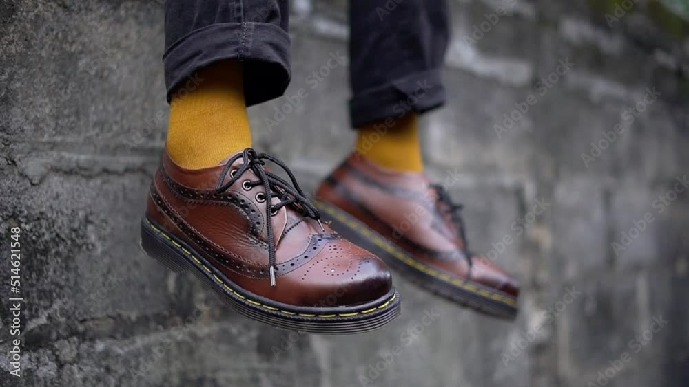 Close up view of genuine leather men's shoes dark brown wingtip brogues shoes handmade by home shoe craftsmen, shoes worn outdoors with matching socks with shoes