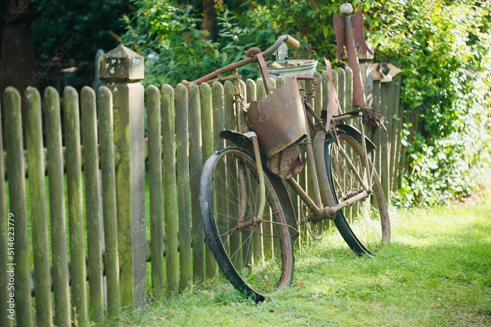 Rostiges Fahrrad am Gartenzaun