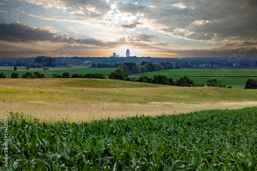 Des Moines skyline visible across farm fields in rural Iowa at sunrise.