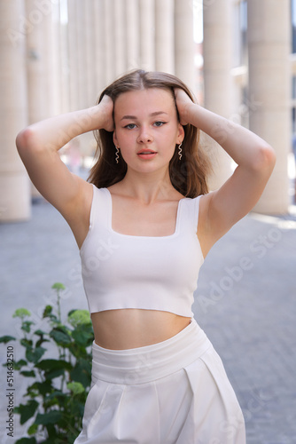 Free Download vertical photo portrait of beautiful girl, young pretty woman standing outdoors holding her hands up, showing demonstrating armpits - GFXLoad