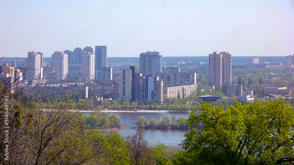 Panoramic view from park of the modern city behind the river. Skyline of european city with highrise buildings near river.