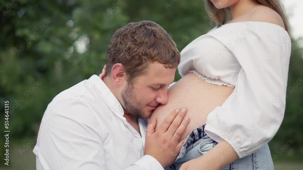 Beautiful pregnant woman and her husband hugging her tummy. Future mother and father are expecting the birth of a baby, their first child. Pregnancy and happiness of a young family. Beautiful pregnant woman and her husband hugging her tummy. Future mother and father are expecting the birth of a baby, their first child. Pregnancy and happiness of a young family.