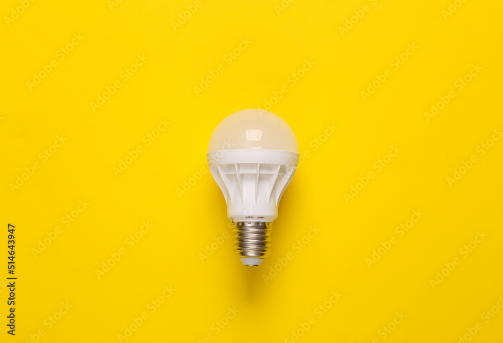 Economy led light bulb on yellow background. Top view Economy led light bulb on yellow background. Top view