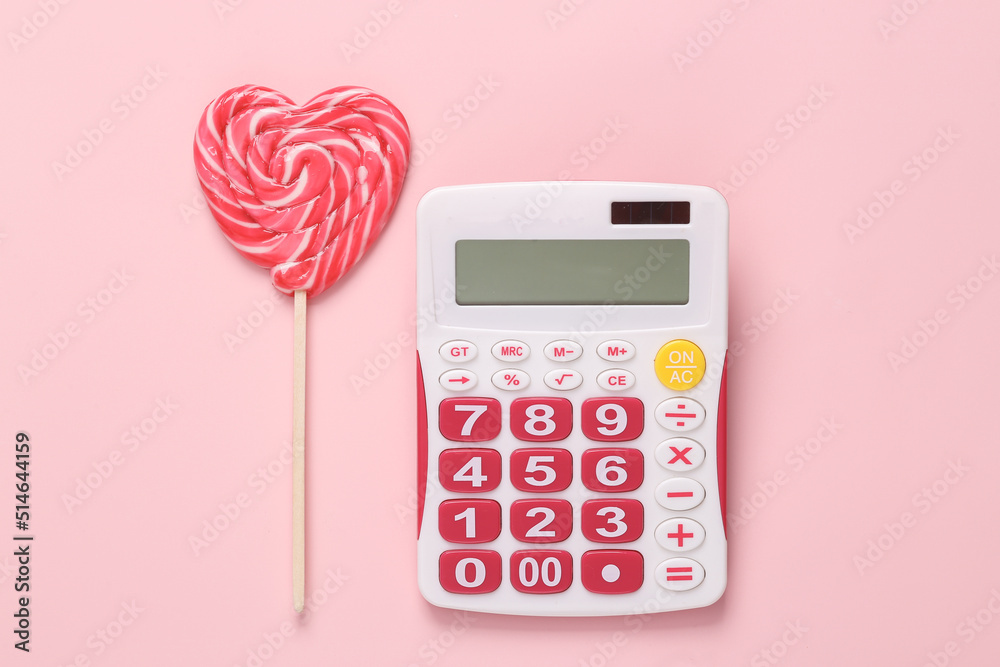 Calculator with lollipop on pink background Calculator with lollipop on pink background