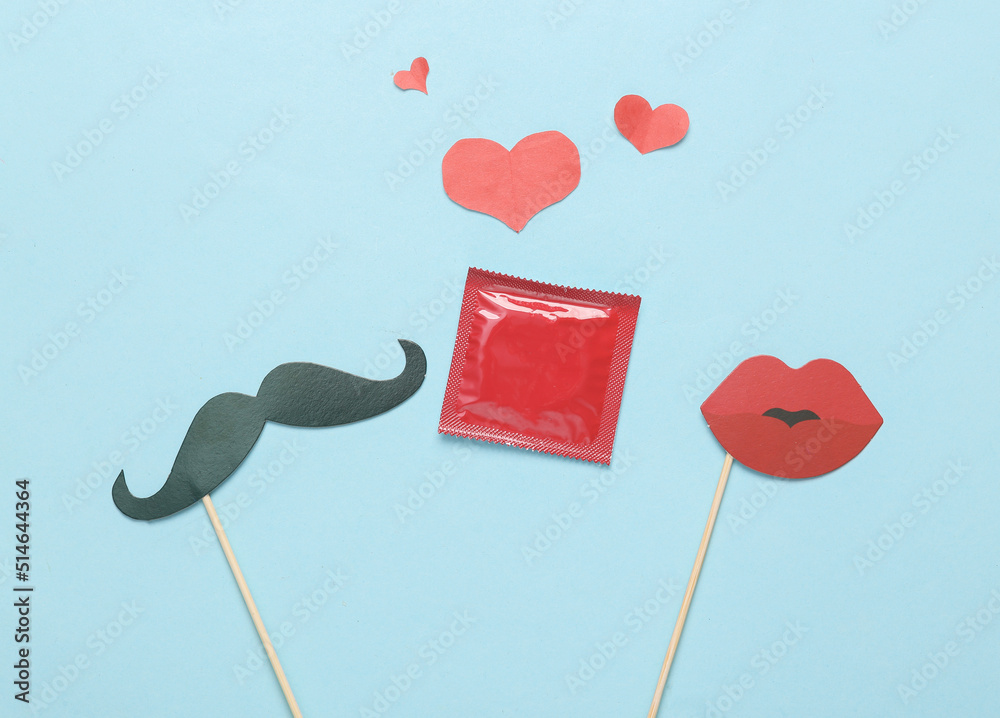 Mustache And Lips On A Stick Condom With Hearts On A Blue Background Mustache and lips on a stick condom with hearts on a blue background
