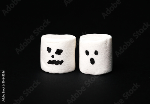 Halloween marshmallows with faces on a black background