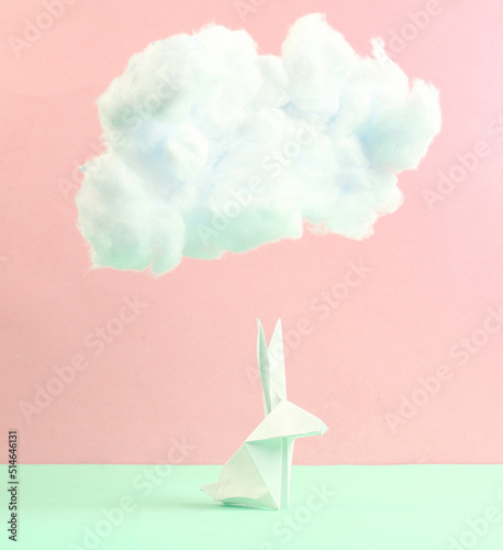 Origami bunny with fluffy cloud on pastel pink green background. Creative easter idea. Minimal concept. Pastel color trend