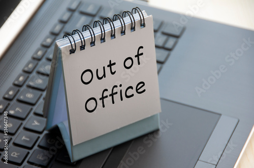 Quadro su tela Out of office text on calendar desk on top of a laptop.