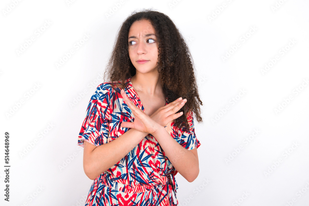 young beautiful girl with afro hairstyle wearing flowered dress Has rejection angry expression on face and crossing hands doing refusal negative sign. young beautiful girl with afro hairstyle wearing flowered dress Has rejection angry expression on face and crossing hands doing refusal negative sign.