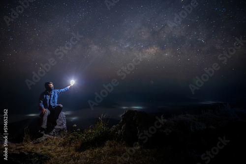 Man sit down on stone at night. Milky way galaxy at night.
