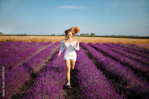 Fototapeta Naklejka Na Ścianę i Meble -  Beautiful girl in white dress in the lavender field on summer day have fine time
