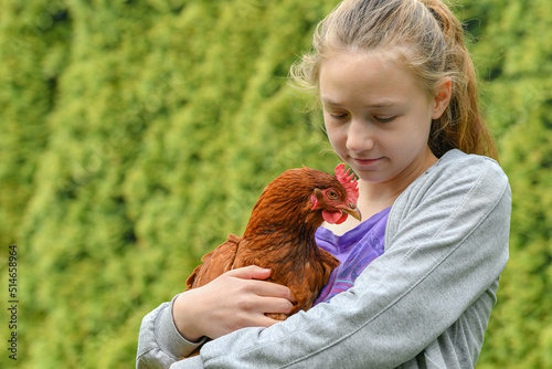 Portrait of a girl with a chicken in her hands.