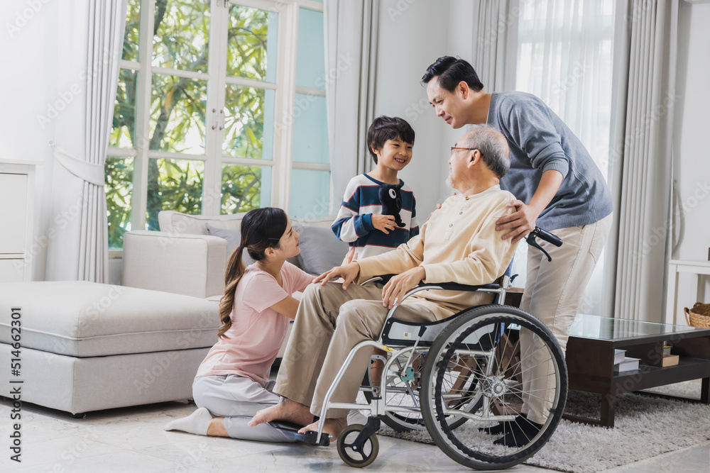 Happy family of senior with beautiful daughter, her husband and grandson take care old man sitting on wheelchair in house, positive dad have strength and positive thinking Happy family of senior with beautiful daughter, her husband and grandson take care old man sitting on wheelchair in house, positive dad have strength and positive thinking