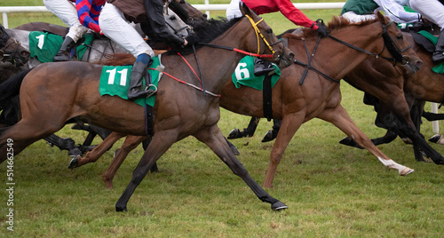 Close up on group of running race horses.