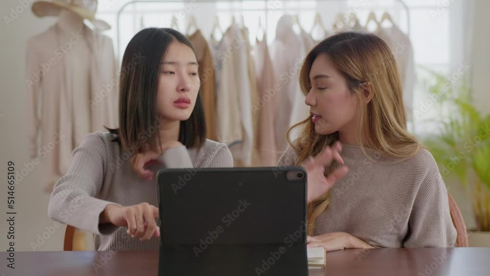 Young asian designer using tablet to design to work. They talking about clothing design at work place. Young asian designer using tablet to design to work. They talking about clothing design at work place.