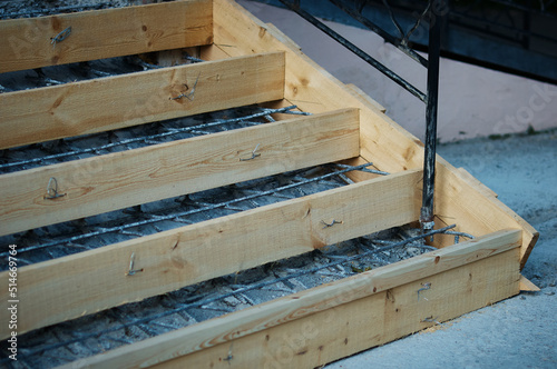 Wooden formwork with metal reinforcement prepared for pouring concrete. Installation using wire. Reconstruction of reinforced concrete stairs. Close up.