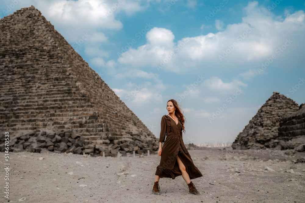 Φωτογραφία Young redhead tourist girl wearing a brown dress standing on the sand in Egypt, Cairo - Giza