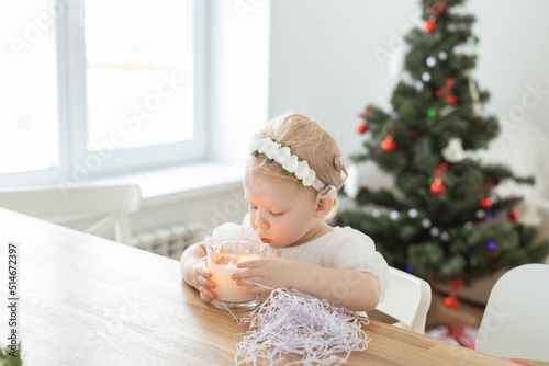 Child girl dressed in christmas dress with cochlear implants having fun at home - diversity and hearing aid and innovating technologies for treatment of deafness. Copy space and place for advertising
