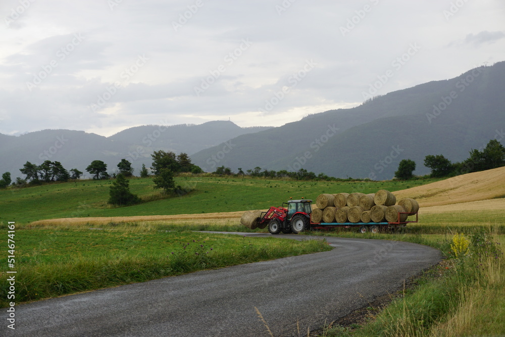 tractor in the mountains carrying hay bales in france