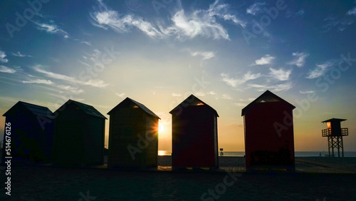 Colorfully painted wooden huts located on the beach by the sea © cribea
