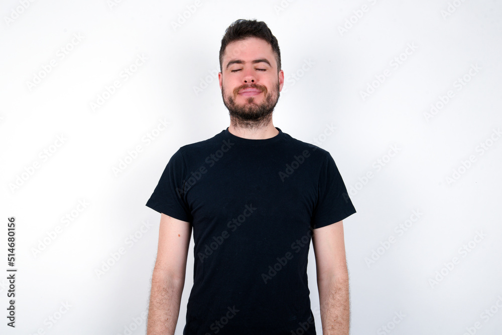 young caucasian bearded man wearing black t-shirt standing over white wall nice-looking sweet charming cute attractive lovely winsome sweet peaceful closed eyes young caucasian bearded man wearing black t-shirt standing over white wall nice-looking sweet charming cute attractive lovely winsome sweet peaceful closed eyes