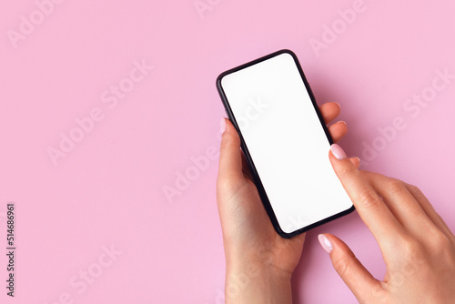 Woman using smart phone on pink background. Closeup of female hands with natural manicure with a mobile phone. Online shopping, business, education, communication concept. Isolated white screen mockup