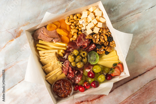 Фотография charcuterie box with cheeses, crackers, strawberries, olives, grapes, cherries,