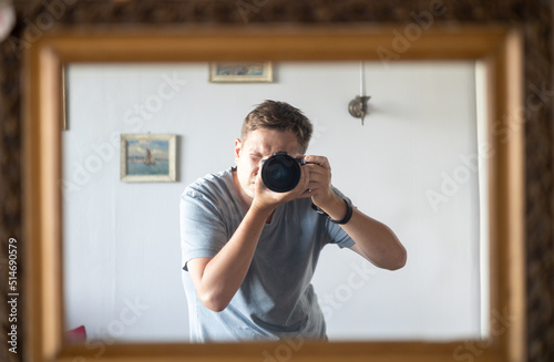 male photographer is taking a selfie photo in an antique mirror, passion photography