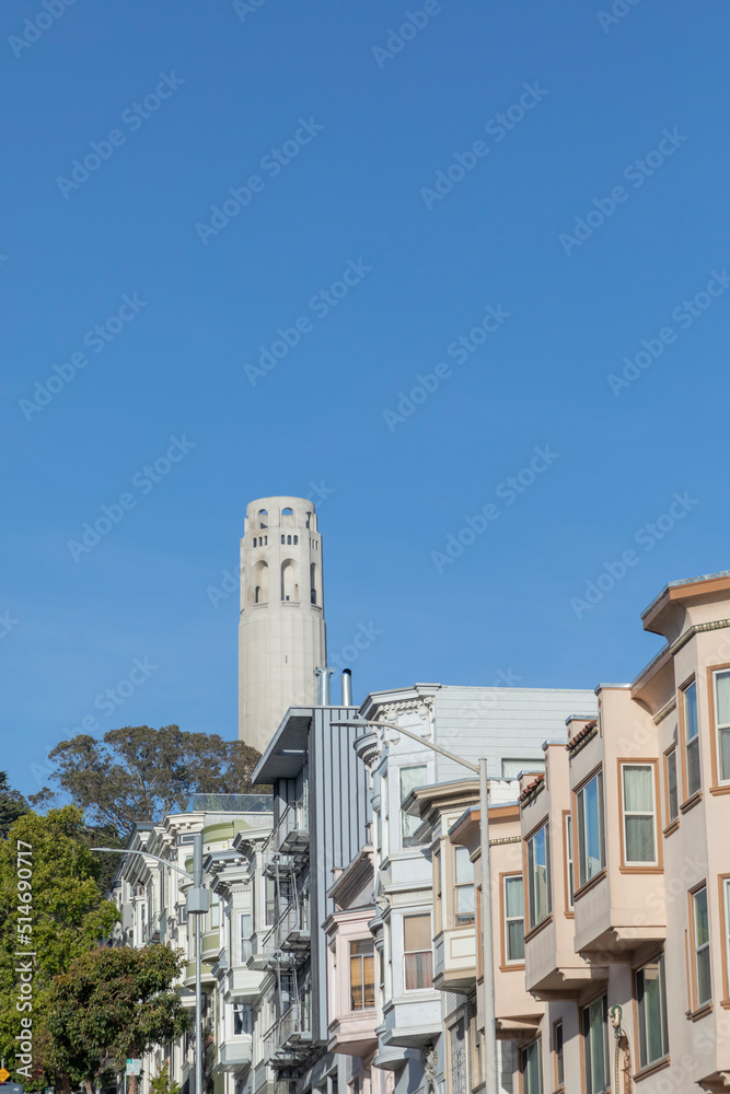 facade of old victorian houses and coit tower in background  in San Francisco