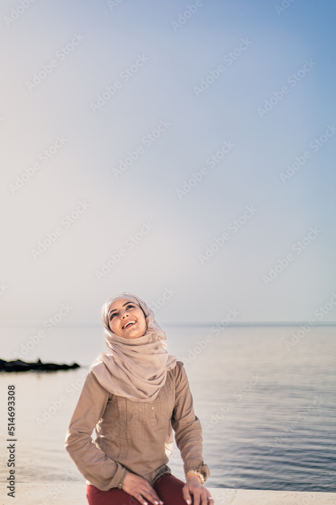 Muslim and modern woman smiling on the beach with hope and happiness Muslim and modern woman smiling on the beach with hope and happiness
