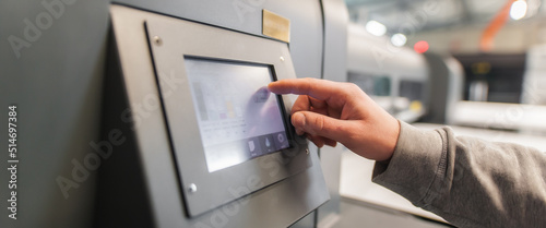 Technician operator checking status on touchscreen front display monitor station