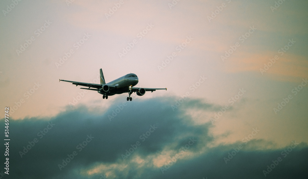 The silhouette of a passenger plane coming in for landing against the backdrop of the sunset sky. The silhouette of a passenger plane coming in for landing against the backdrop of the sunset sky.