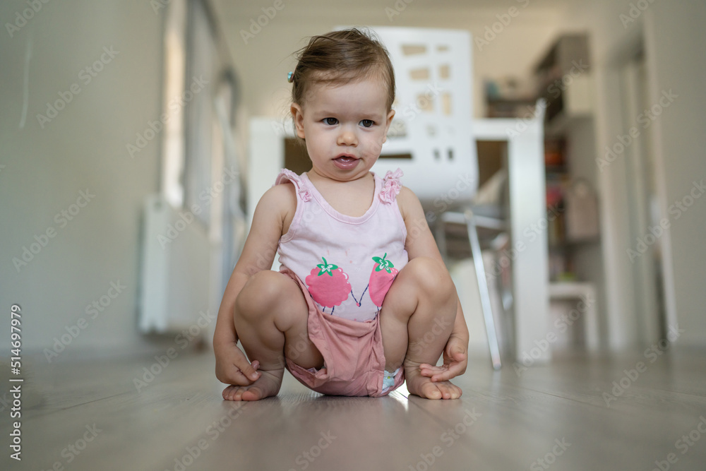 One toddler squatting and playing at home in the living room with Early child development and learning concept One toddler squatting and playing at home in the living room with Early child development and learning concept