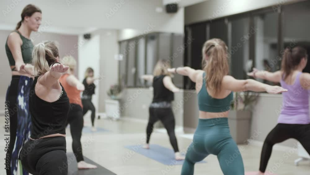 Yoga instructor having class with students. Girls practicing yoga. Stretching poses exercise.. Yoga instructor having class with students. Girls practicing yoga. Stretching poses exercise..