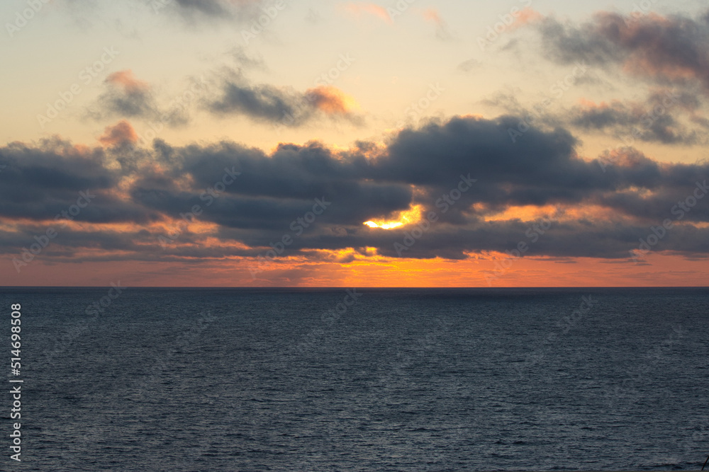 Partially clouded sunset in the ocean