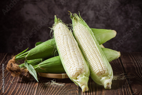 Fotografija sweet white corn cobs on wooden table