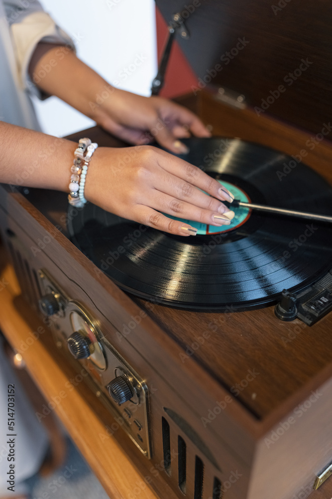 Obraz premium details such as placing music on a record player with vintage wooden design, player with acetate disc, old objects, hands